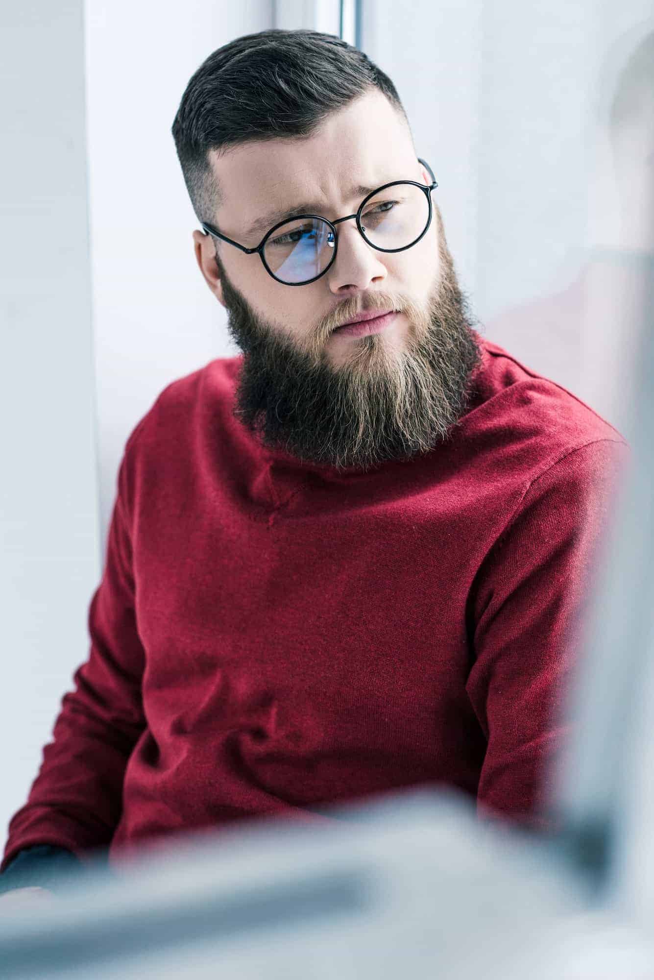 Portrait Of Handsome Pensive Businessman In Eyeglasses Looking Away.jpg