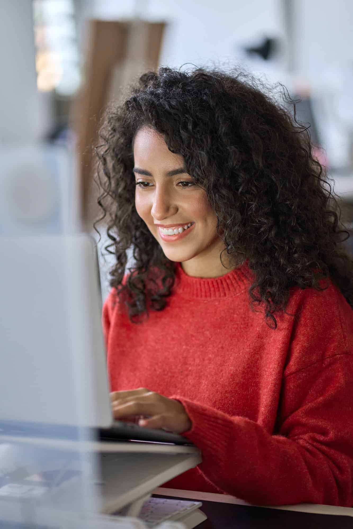 Young Happy Latin Woman Student Elearning Using Laptop Vertical Shot.jpg